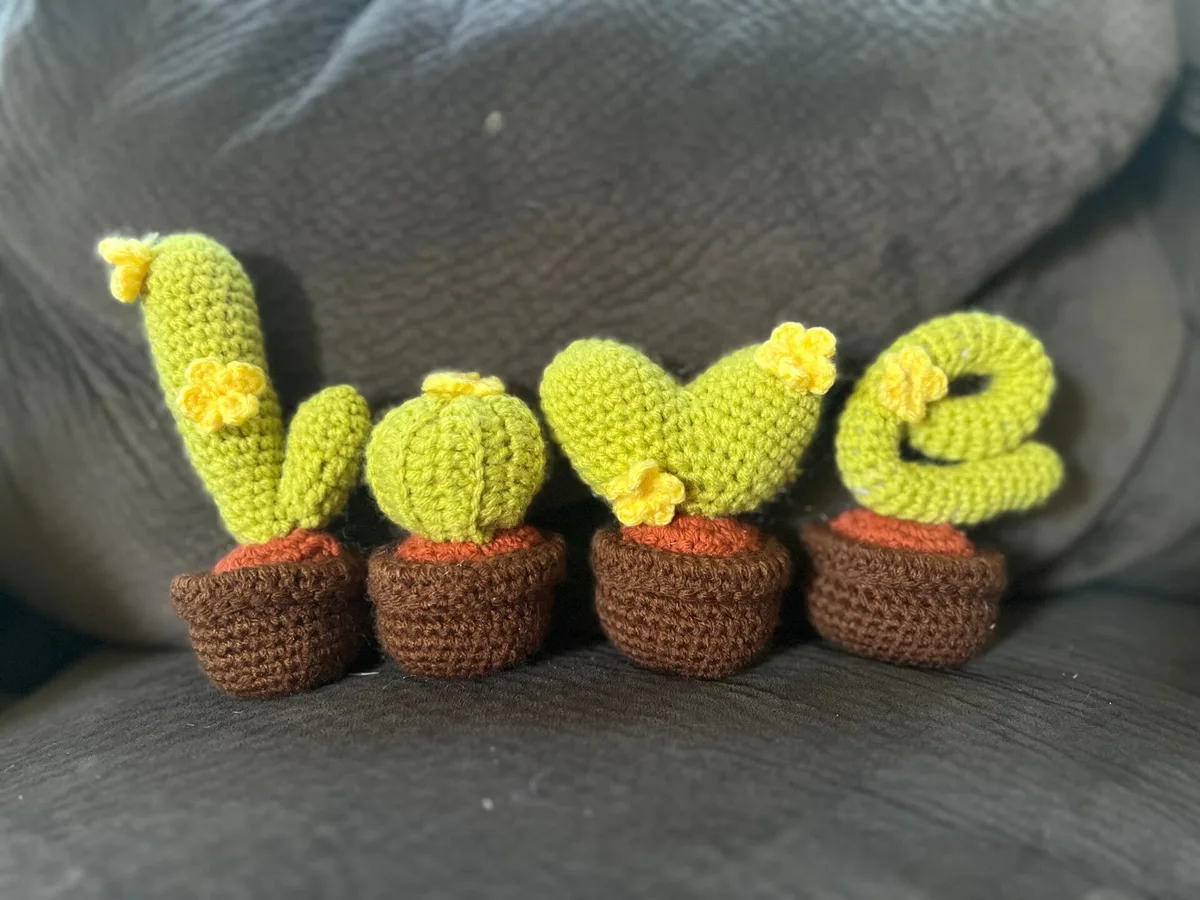 Four crochet cacti in pots spelling LOVE