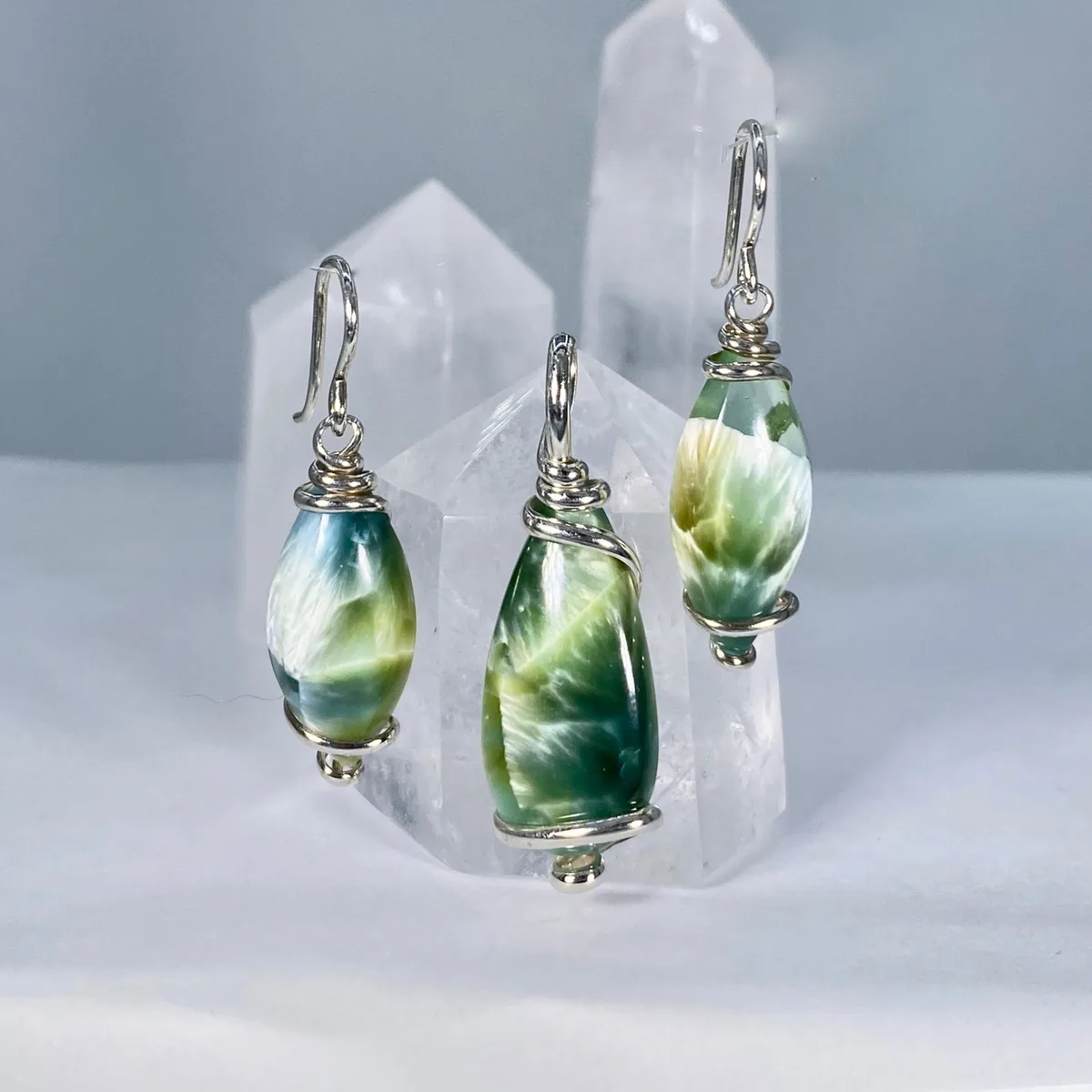 Green-and-white Bridewell Stone drop earrings against quartz points