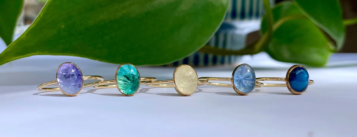 A row of rings set with round Bridewell Stone cabochons