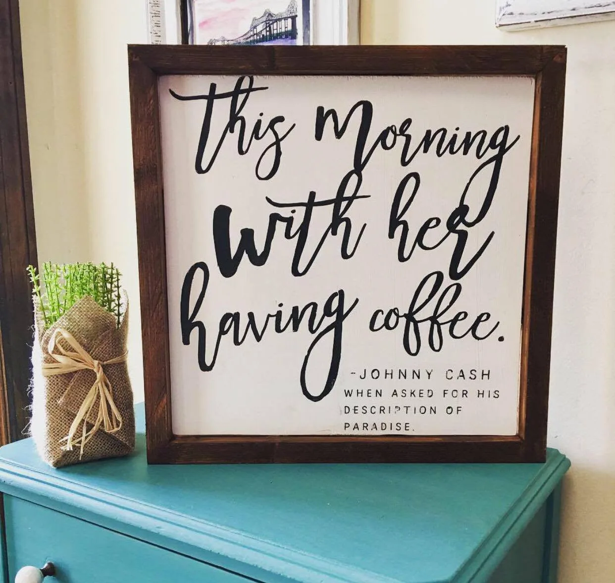 A hand-painted Johnny Cash quote sign in a dark wood frame