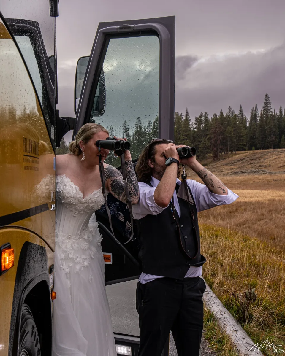 Katie and Isaac birding with binoculars in Yellowstone on their wedding day