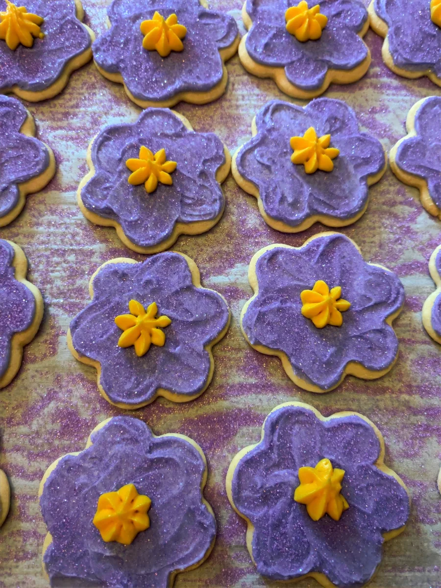Purple flower sugar cookies with yellow buttercream centers