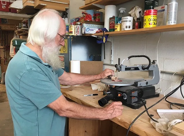 Steve Kosztala cutting a light chamber on the scroll saw in his workshop