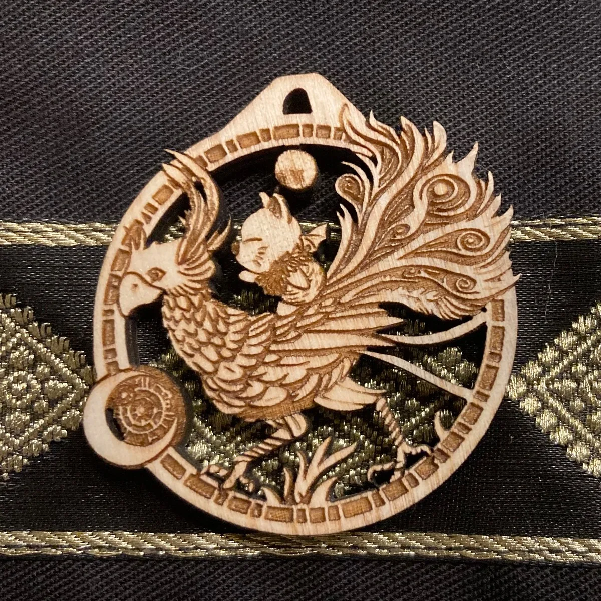 A small engraved medallion of a chocobo and moogle