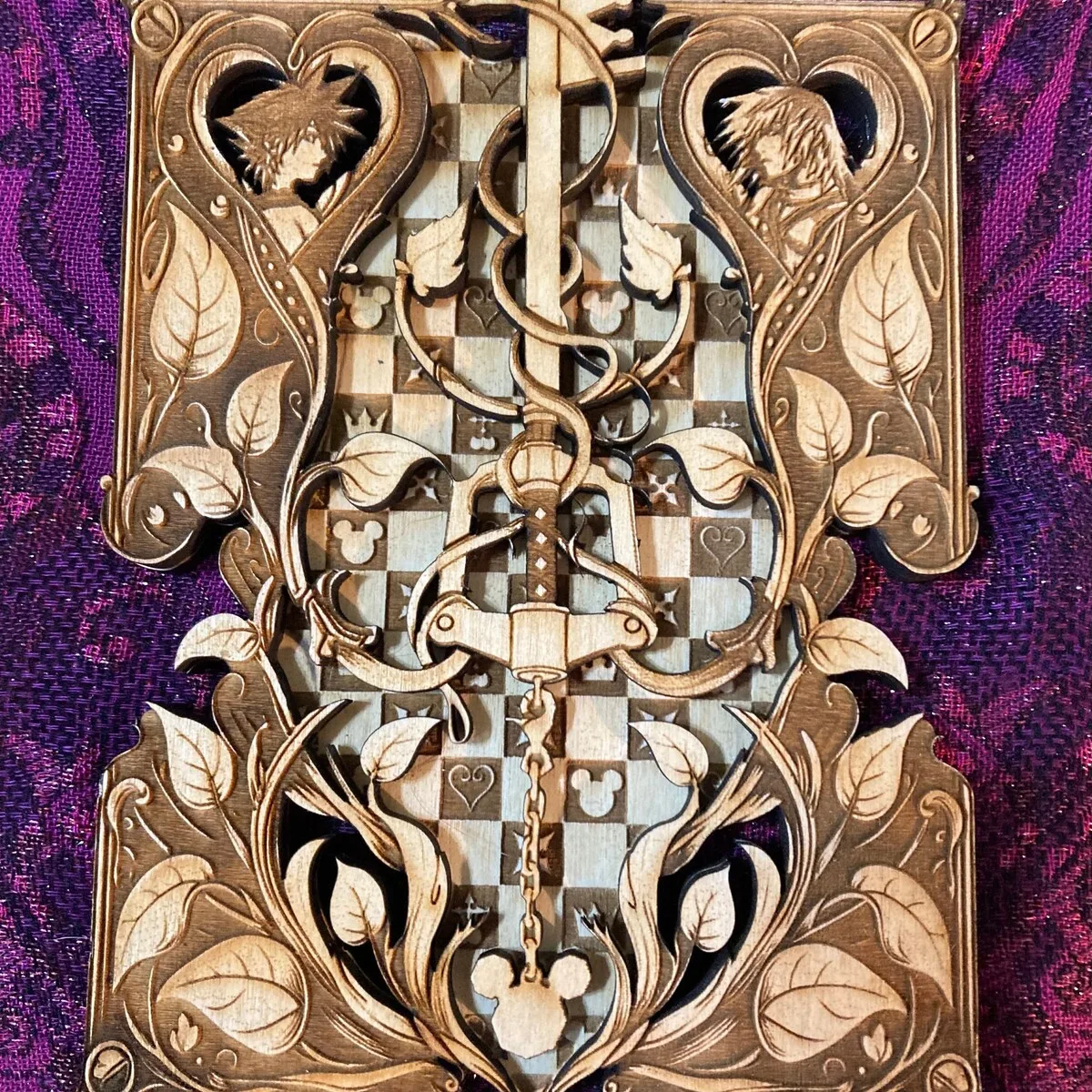 A Kingdom Hearts keyblade engraving with vines and a checkerboard