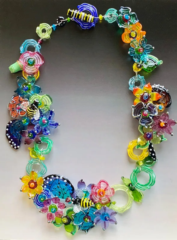 The Secret Garden necklace: a ring of glass flowers, bugs and swirls