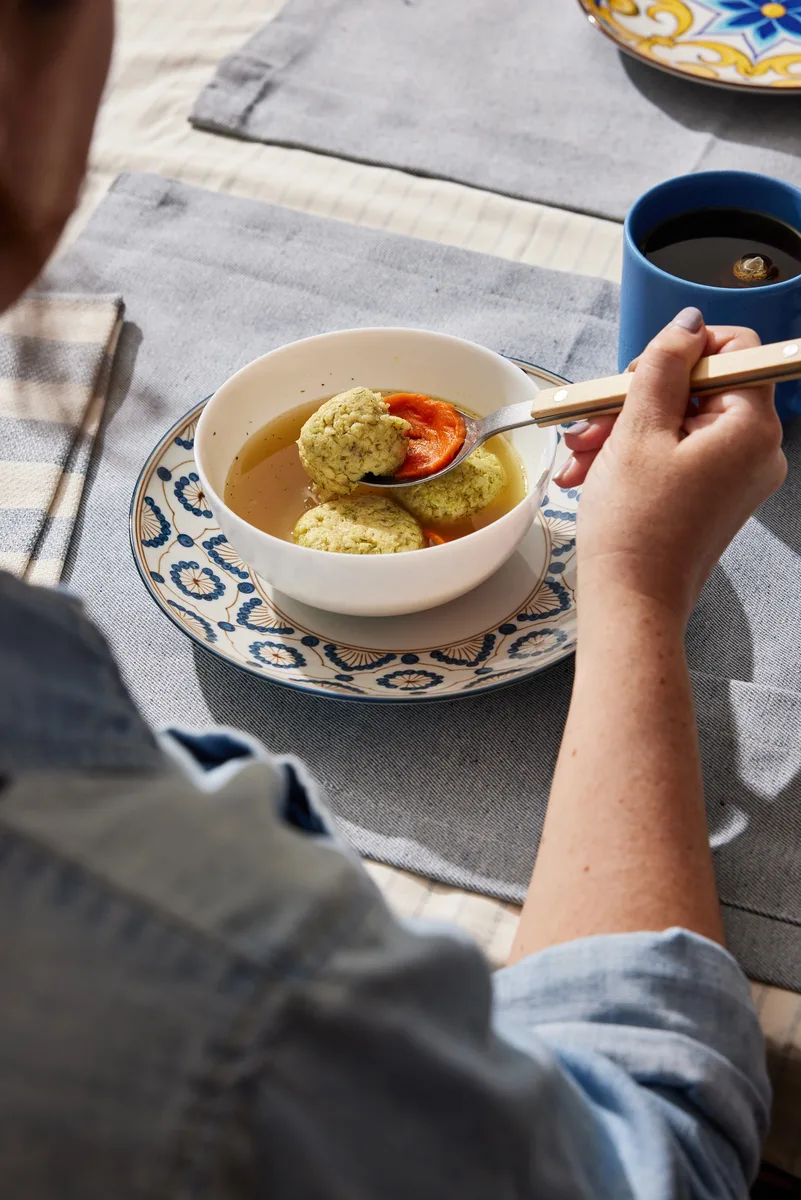A bowl of matzo ball soup on the table