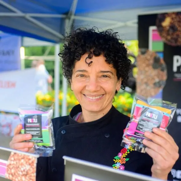 Holding up a pouch of alegrias at the Paktli market tent