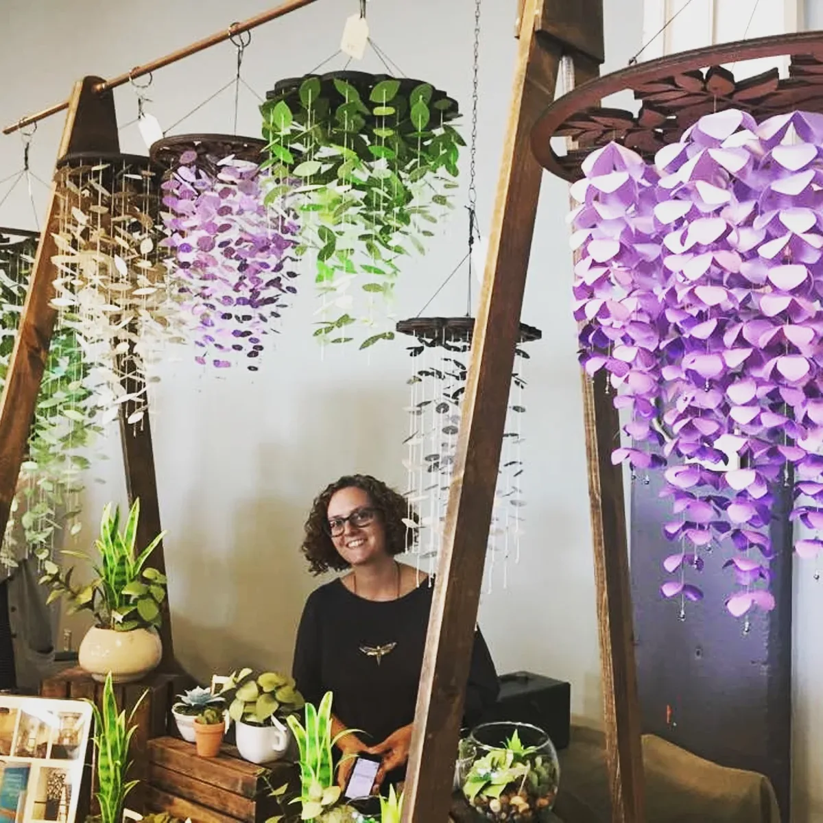 Jessica Wolf among her hanging paper chandeliers and paper plants