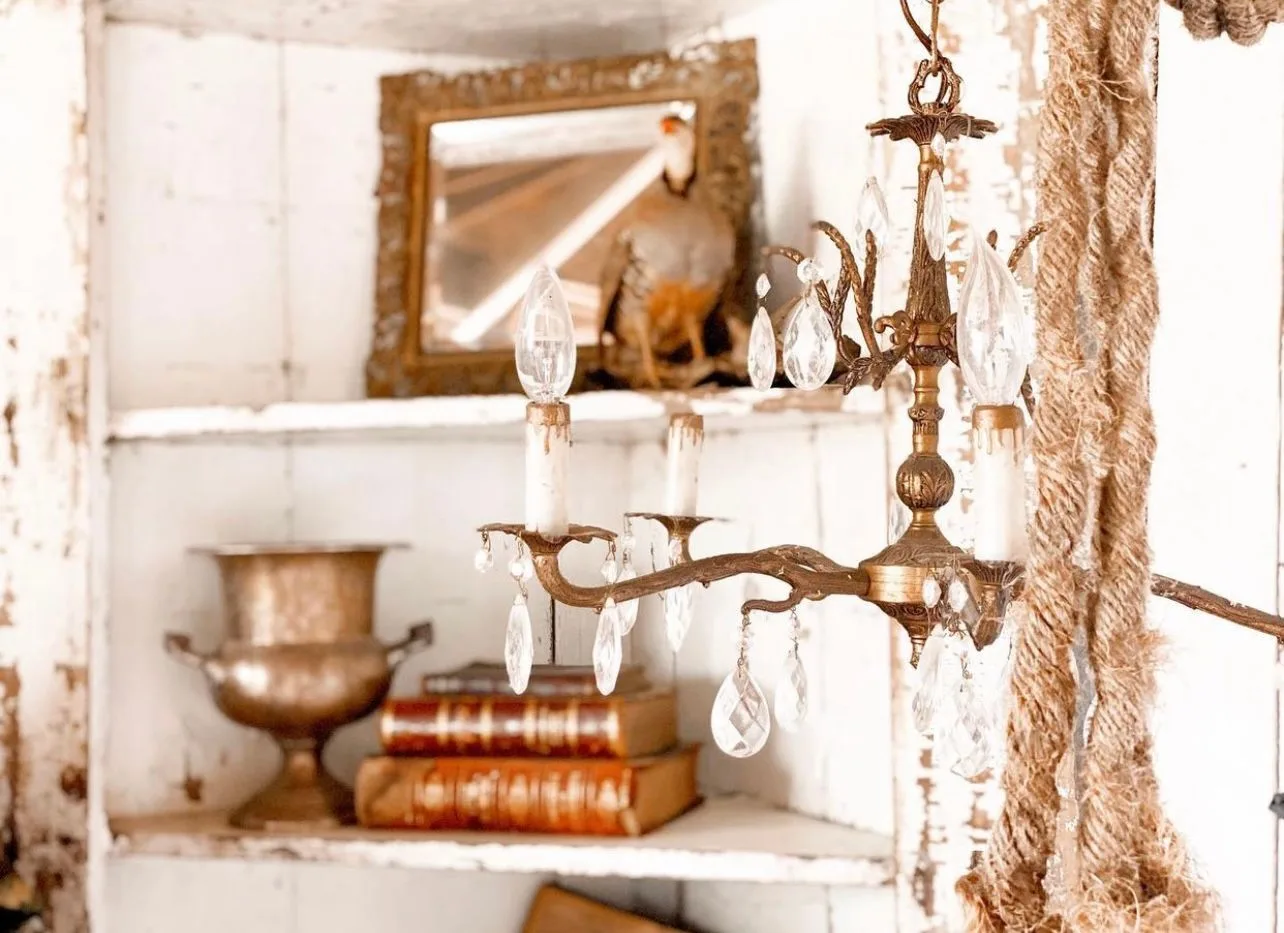 A vintage vignette: brass, chandelier crystal, old books and a gilt mirror