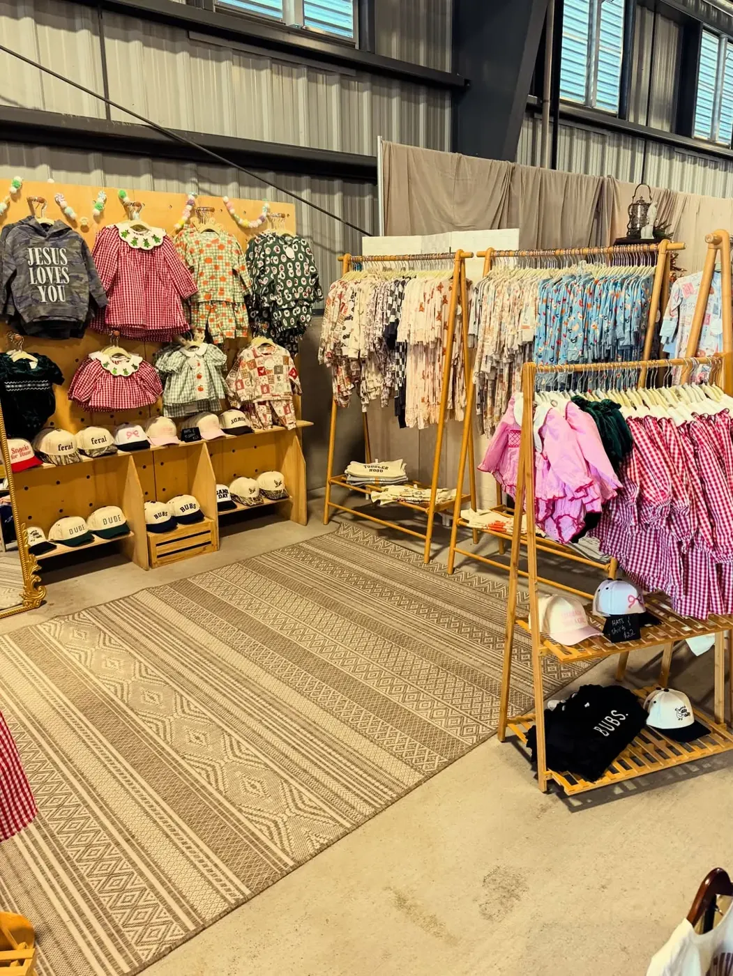 Teddy & Co market booth: racks of kids' clothes, hats and shoes
