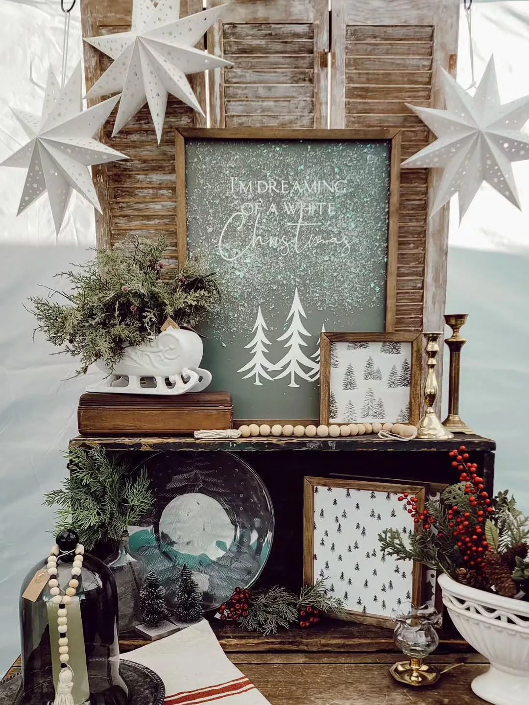 A faux-snow "white Christmas" sign styled with greenery and framed prints