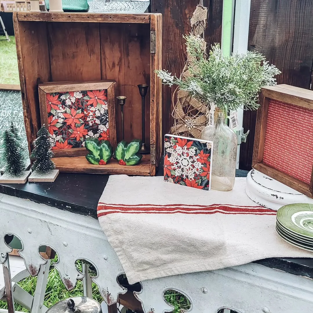 Framed poinsettia and snowflake prints in a wooden crate