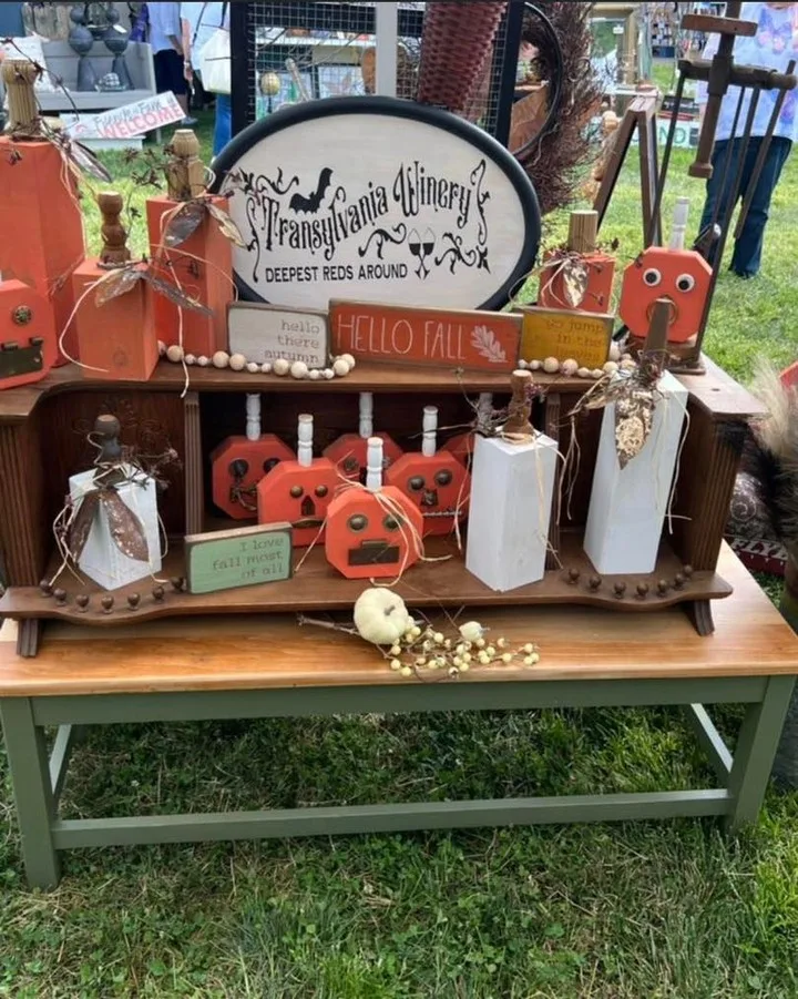 Handmade fall decor: wooden pumpkins and painted signs on a vintage bench
